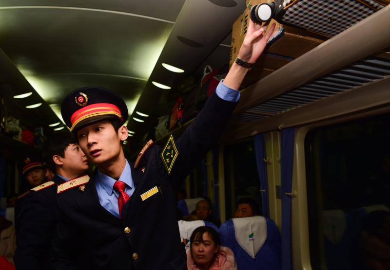 1月24日,z184列车的列车长刘一鸣在帮助旅客整理行李.
