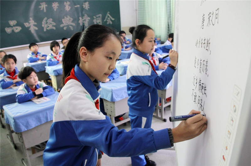 2月13日，山东省博兴县实验小学学生张淑萱（前左）在开学第一课“品味经典诗词会”上默写古诗词。