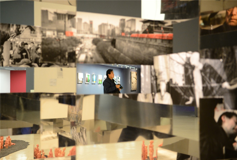 2月20日，观众从展览展出的大型装置《幻城》旁边经过。