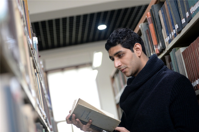 3月28日，西安交通大学丝路奖学金获得者、巴基斯坦留学生谢赫扎德（中文名：王子）在图书馆里借阅书籍。目前他在西安交通大学管理学院攻读管理科学与工程硕士学位。