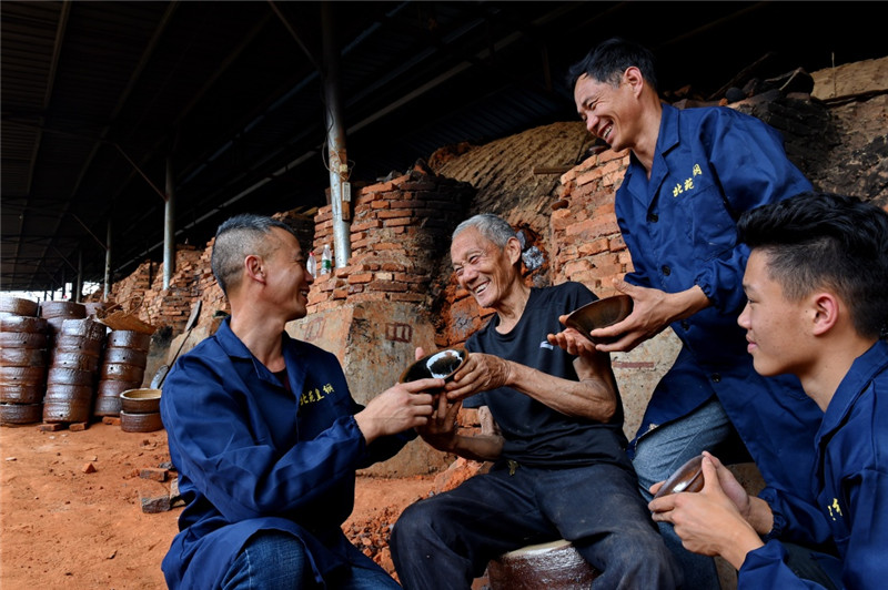 福建省建瓯市北苑皇纲工艺厂85岁的陶瓷艺人黄志松（左二）在查看工人烧制的建盏（5月20日摄）。