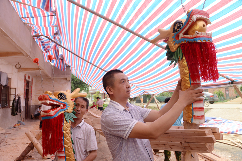 5月23日，江西省南昌市新建区松湖镇的群众在安装龙舟的龙头。