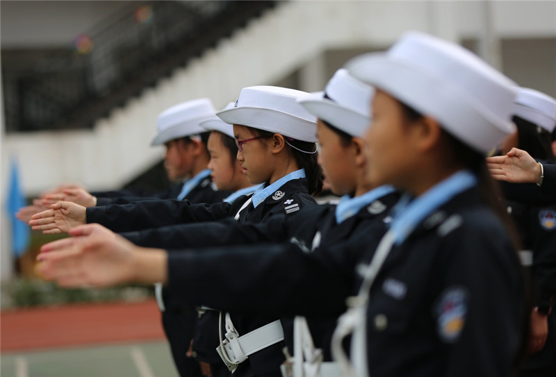 军地小学的小交警在学习交通警察指挥手势。