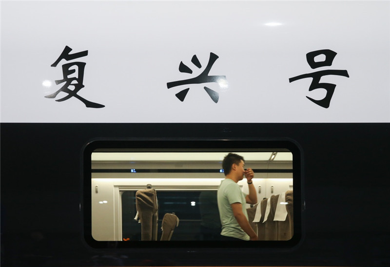 6月26日，在上海虹桥火车站，乘客在“复兴号”G124次列车内行走。