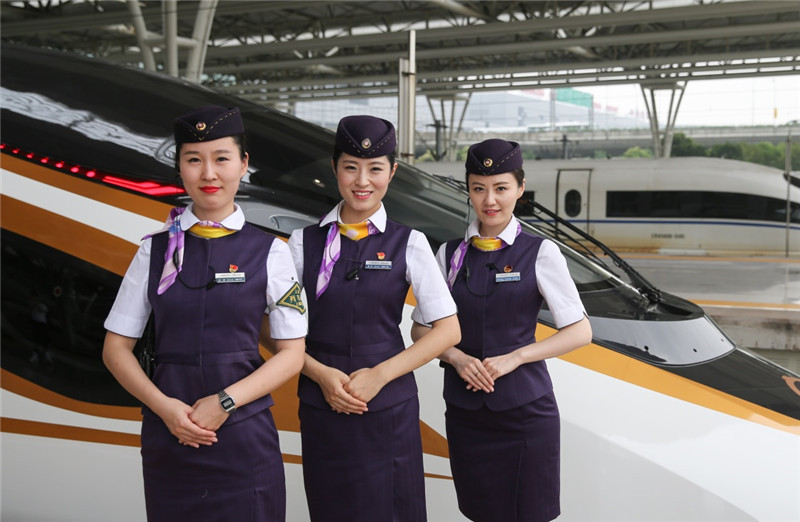6月26日，在上海虹桥火车站，乘务人员站在“复兴号”G124次列车旁。