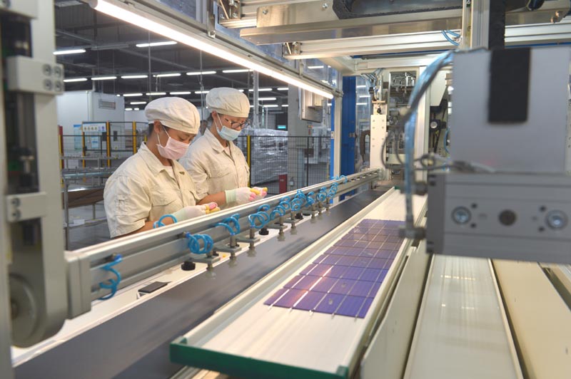 7月24日,江苏林洋新能源有限公司的员工正在利用自动焊接设备对光伏组件进行焊接。