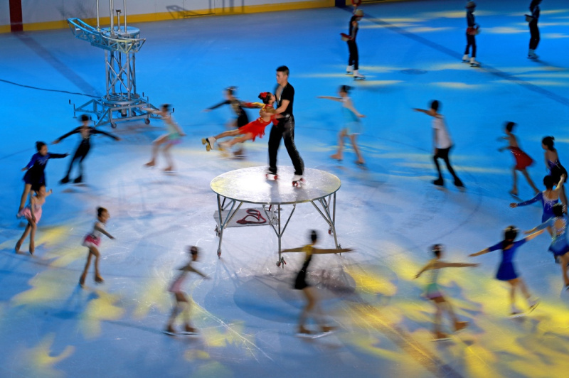 7月30日,在河北奥林匹克体育中心,演员在四季冰雪推广活动中表演冰上杂技。