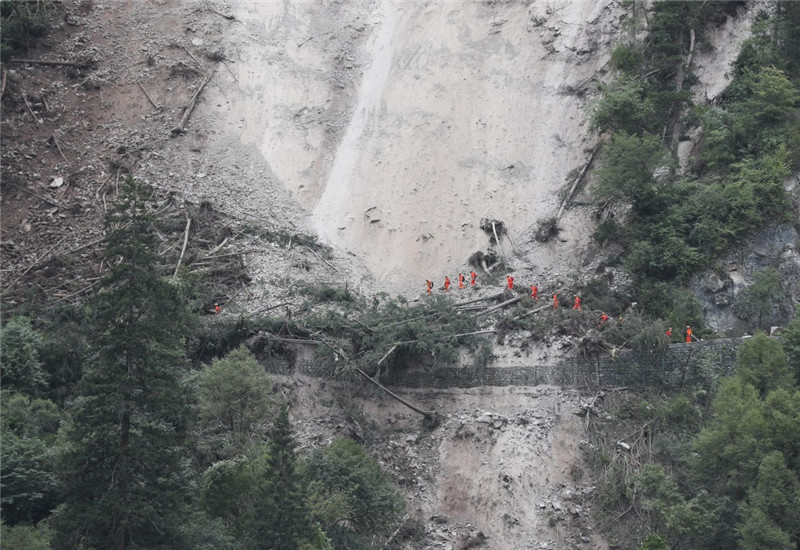 8月10日,一组搜救队伍通过九寨沟景区五花海到熊猫海的滑坡路段。