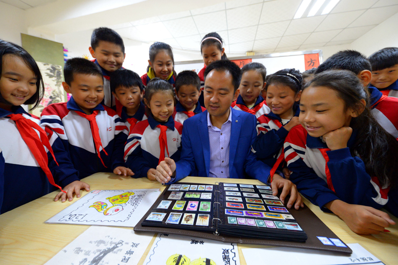 10月9日，邯郸市邯山区南关小学教师在给学生介绍邮票知识。
