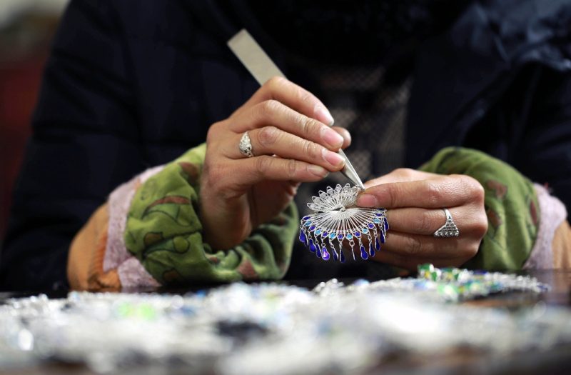 1月10日,在贵州省黔东南苗族侗族自治州丹寨县,技术工人在制作银饰.