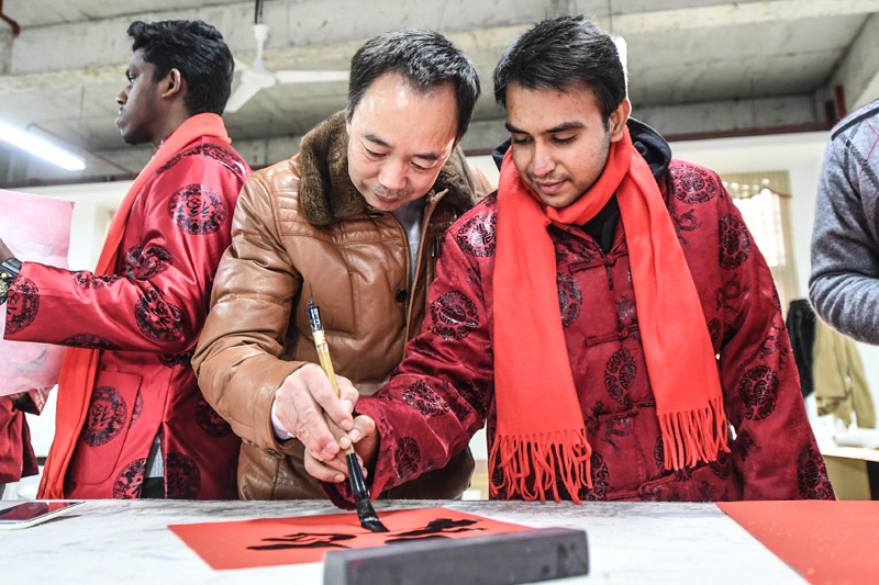 2月7日，辽河画院书法家指导锦州医科大学巴基斯坦留学生瓦斯用毛笔写福字。