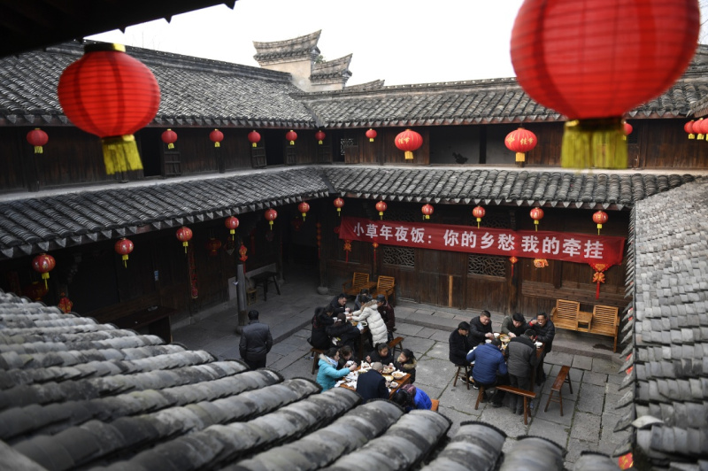 2月8日,拾荒者及亲属在宁波市奉化区滕头村百年老屋院子里品尝志愿者