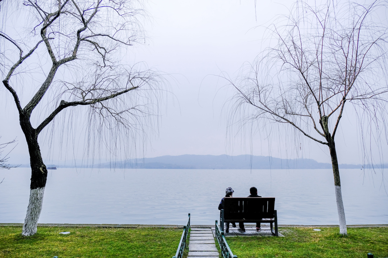 2月16日，游客在西湖边观赏风景。