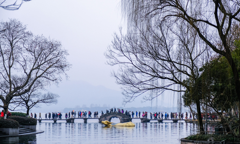 2月16日，游客在西湖边的涌金公园观赏风景。