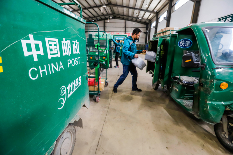 中国邮政集团河北省遵化市分公司的工作人员将快递包裹装车准备派件(5