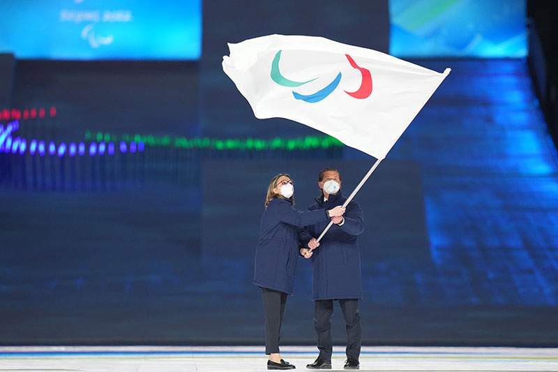 和科尔蒂纳丹佩佐市市长盖迪纳在会旗交接仪式上挥舞国际残奥委会会旗