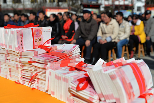 甘肃省陇南市康县城关镇凤凰谷村“村民分红扩股”大会的会场上码放着用于分红和奖励的现金（2015年12月25日摄）。2014年以来，凤凰谷村在陇南市“双联”扶贫单位帮助下，启动“股份制”脱贫试验，利用当地乡村特色旅游资源开办乡村旅游度假公司，村集体和村民入股成为公司股东。