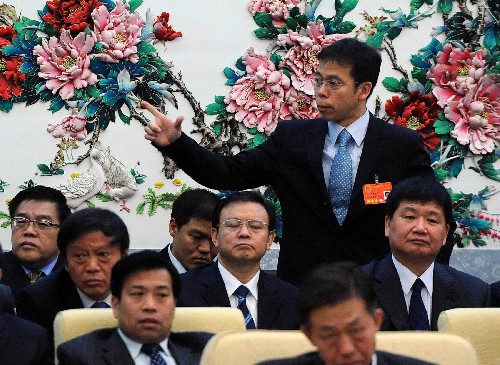 全国人大代表、河北秦皇岛市代市长朱浩文(后立者)说,秦皇岛市是沿海旅游城市,应借助奥运会带来的机会,做大做强旅游业等传统优势产业,加速产业换代升级,落实“绿色奥运、科技奥运、人文奥运”的理念,发展“高科技、低能耗、无污染”产业,促进经济由粗放扩张型向精细集约型转变。 新华社记者 高洁 摄