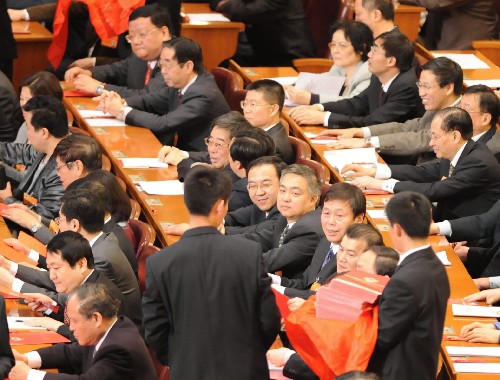 3月13日,全国政协十一届一次会议在北京人民大会堂举行第四次全体会议,选举十一届全国政协主席、副主席、秘书长和常务委员。这是工作人员在发选票。新华社记者 李学仁 摄