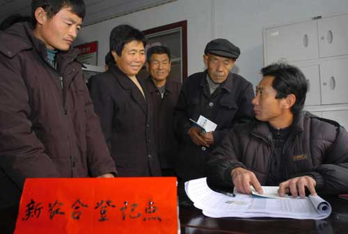 “今年中央财政安排‘三农’支出5625亿元,比上年增加1307亿元。”温家宝总理在政府工作报告中宣布的这一惠农新举措,成为连日来两会会场上代表委员们热议的亮点。 图为2007年12月12日,山东无棣埕口镇后埕村村民在登记参加新型农村合作医疗。