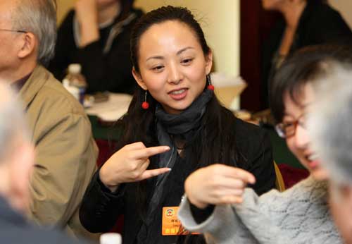 3月4日,中国残疾人艺术团艺术总监邰丽华委员在通过手语翻译与其他委员交流。新任全国政协委员的邰丽华准备在这次会议上提交一份关于进一步完善残疾人无障碍信息等方面政策的提案。 新华社记者 庞兴雷 摄
