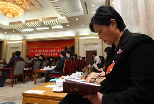 第一次当选全国人大代表的安徽省砀山县葛集镇白腊园村党支部书记刘瑞莲在认真准备发言。她表示,这几年南方部分地区雨量较大,农田水利设施损毁严重,呼吁加大农田水利、道路交通等基础设施的资金投入,为农村发展、农民增收增加后劲。 新华社记者刘卫兵摄