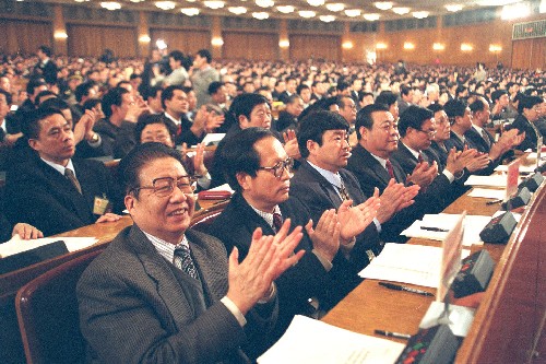 这是1999年3月15日,出席九届全国人大二次会议的代表们热烈鼓掌,庆祝邓小平理论和“依法治国”写入宪法。新华社发