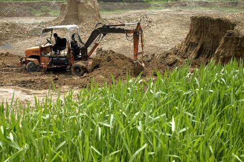 2007年5月21日,一辆铲车在甘肃省临夏市枹罕镇的一处农田边取土,用于烧制国家早已明令禁止的实心砖瓦,当地30多家砖瓦生产企业在基本农田保护区范围内取土,造成上千亩水浇地大幅度减产甚至无法耕种。新华社发