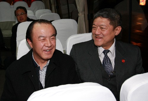 2月28日,全国政协委员林炎志(右)和刚占标下列车后在换乘的工作车上交谈。 当日6时,来自吉林省的全国政协委员乘坐Z62次列车抵达北京火车站,成为首批抵京参加全国政协十一届一次会议的京外委员。 新华社记者庞兴雷摄