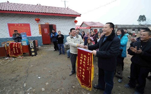 1月23日,在四川地震重灾区什邡市双盛镇万缘村馨凉新村落成典礼上,受灾群众向当地政府和建设单位赠送锦旗。 新华社记者 李晓果 摄
