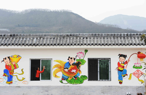1月24日,在四川省绵竹市棚花村,一名妇女在绘有绵竹年画的新房擦玻璃。这个地震后重新建起的农房,家家墙上新绘制的绵竹年画,为节日的农家增添了喜庆气氛。 棚花村多年来形成了在墙上绘制中国四大年画之一的绵竹年画的习俗,并已成为远近闻名的旅游观光村。新华社记者 李晓果 摄