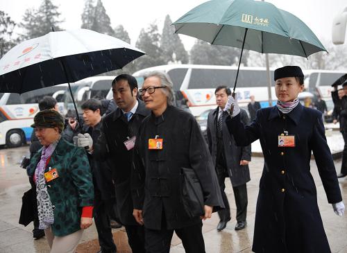 3月14日,第十一届全国人民代表大会第三次会议将在北京人民大会堂举行闭幕会。北京下起了雨夹雪,工作人员打着伞迎接代表。新华社记者 杨宗友 摄