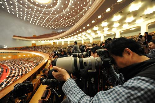 3月14日,第十一届全国人民代表大会第三次会议在北京人民大会堂举行闭幕会。这是摄影记者在现场采访。 新华社记者 杨宗友 摄