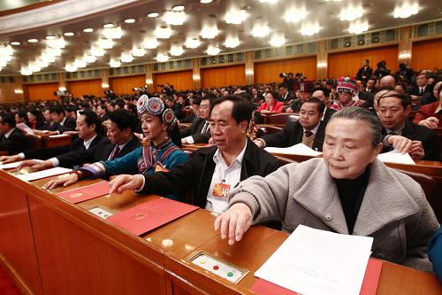 3月14日,第十一届全国人民代表大会第三次会议在北京人民大会堂举行闭幕会。这是全国人大代表在按表决器。新华社记者 刘卫兵 摄