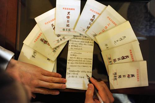 3月10日,全国人大代表、广西兴业县民政局局长梁启波在整理“民情日记”。梁启波喜欢别人叫他“阿波”,18年来,这位朴实的代表用朴实的记录方式,写下了一本本朴实的“民情日记”。“我一共写了70多本民情日记,这是我18年来的习惯,已经改不掉了。”操着一口广西话,梁启波认真地对记者说,“我是搞民政工作的,记日记能够让我及时记录下百姓的疾苦,尽量为他们提供必要的帮助。”正在北京举行的两会上,来自全国的数千名代表委员正在履行自己记录民意、集思民意,反映民意的神圣职责。日记、DV、博客……虽然他们采取的记录方式不同,但目的是相同的,那就是更好地履行职责,反映最基层百姓的心声。新华社记者 金良快 摄