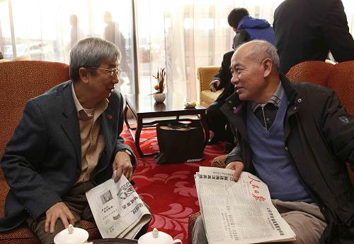 3月2日,来自香港和澳门的代表、委员抵达北京首都机场,准备出席即将召开的两会。这是来自香港的全国政协委员王国强(左)和陈万雄在休息室里交谈。新华社记者 刘卫兵 摄
