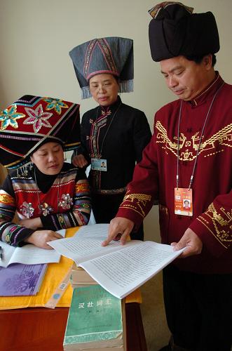 3月5日,民族语文翻译组工作人员覃祥周(右一)、李秀玲(右二)和吴玉富正在研究汉、壮语文翻译。根据党的民族政策和国家的法律法规要求,方便两会少数民族代表委员,由中国民族语文翻译局组建的十一届全国人大四次会议和全国政协十一届四次会议秘书处民族语文翻译组,负责用蒙古、藏、维吾尔、哈萨克、朝鲜、彝、壮7种民族文字翻译、印刷大会文件并向大会会场提供少数民族语言同声传译;负责向中央人民广播电台和全国有关少数民族地区的报社、电台、电视台提供少数民族文大会主要文件。新华社记者 郭刚 摄