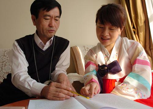 3月5日,民族语文翻译组工作人员李明根(左)和许洪淑正在研究汉、朝语文翻译。新华社记者 郭刚 摄