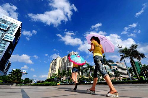 两位姑娘走过蓝天白云下的广西南宁市街头(2010年7月4日摄)。环境保护与人类的健康生活息息相关。“十一五”期间,我国深化自然生态保护工作,加大环境污染防治力度,陆续完成了一系列生态环保目标,在为人民群众提供安居乐业美好环境的同时,走上了一条绿色、生态、环保的可持续发展道路。新华社记者 黄孝邦 摄