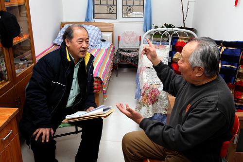 2月28日,在北京市远洋沁山水公租房项目区,全国政协委员、天津市美术家协会副主席王书平(左)在租户石连瑞家里了解情况,征求提案意见。新华社记者 金立旺 摄