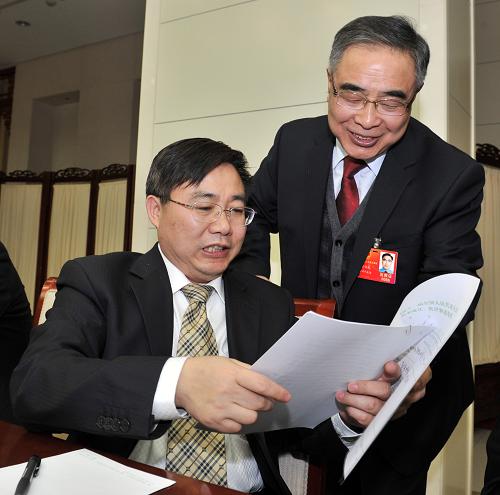 3月4日,天津代表团在讨论拟向大会提出的重要议案或建议的全团会议中,全国人大代表张伯礼离席向全国人大代表何志敏讲解自己关于《加强中青年科技人才政治思想教育》的建议,寻求他的支持和签名。新华社记者 岳月伟 摄