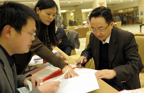 3月1日,来自云南的全国政协委员焦家良(右)在驻地领取会议材料。新华社记者 杨宗友 摄