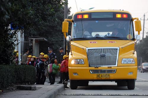 这是浙江省德清县育才学校的小学生放学后在老师的指挥下乘坐校车(2011年11月21日摄)。在今年的地方两会上,“校车安全”成为一大焦点,并在多地政府工作报告中被提及。“校车安全”从未像今天这样引发公众高度关注。新华社记者 鞠焕宗 摄