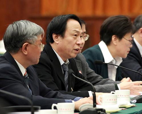 全国政协委员吴以岭(左二)认为,应建立中西医并重,符合中国国情的医疗卫生服务体系,加强中西医自主创新体系建设,促进民族医药产业发展。 新华社记者 庞兴雷 摄