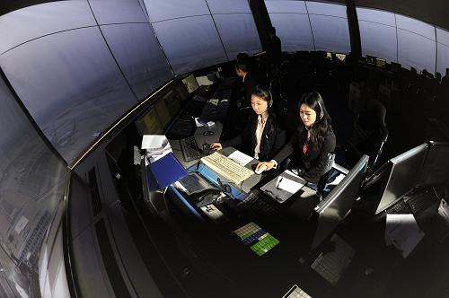 3月4日,民航华北空管局终端管制中心管制员阚侃(前左)、刘昳娴(前右)在首都国际机场塔台指挥航班。在中国最繁忙的机场——北京首都国际机场,有一支由39名女管制员组成的管制队伍,她们隶属于民航华北空管局终端管制中心,肩负为飞机起飞着陆提供导航服务和放行许可、协调机场安全运行。2011年首都机场单日最高起降数达1777架次,小时高峰达106架次,居于全国之首、全球第六,女管制员承担了其中一半的航班量。遇有特殊情况时,女管制员耐心、细心和善解人意的悦耳声音更能平复飞行员紧张急躁的心情。投入工作三年来,她们以严谨的工作作风和精湛的指挥技能服务“春运”“两会”“黄金周”以及应对雷雨冰雪天气、险情特情的保障工作,实现了零事故,零差错。新华社记者 杨光 摄