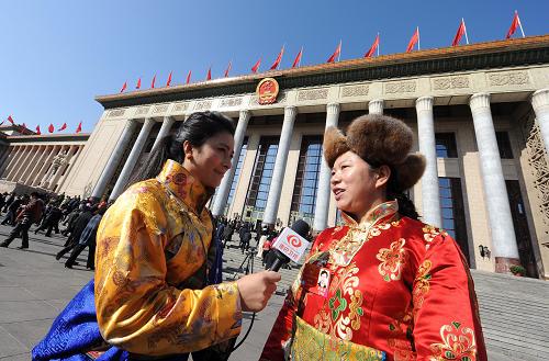 3月14日,第十一届全国人民代表大会第五次会议在北京人民大会堂闭幕。这是闭幕会前,全国人大代表王树芬(右)在大会堂前接受采访。 新华社记者 杨宗友 摄