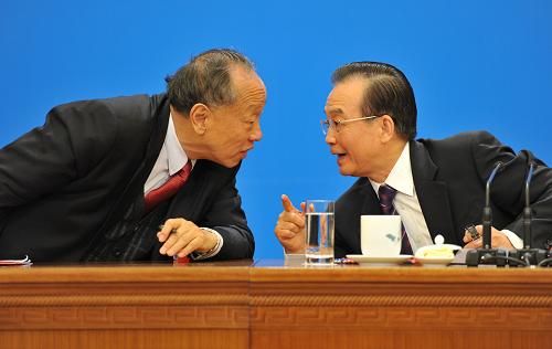 3月14日,国务院总理温家宝在北京人民大会堂与中外记者见面,并回答记者提问。这是温家宝与李肇星在交流。 新华社记者 黄敬文 摄