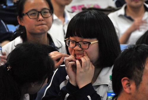5月21日,南昌市豫章中学高三年级的两名女生在考前减压辅导课上的“‘八颗牙’微笑减压”环节中互相逗乐:“来,让我看看你露出了几颗牙!”新华社发(陈子夏摄)