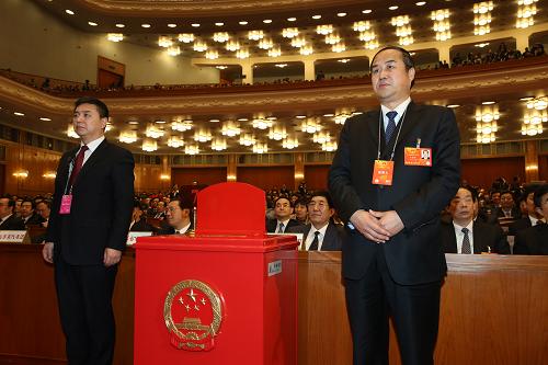 3月16日,十二届全国人大一次会议在北京人民大会堂举行第六次全体会议。这是监票人(右)在投票箱旁就位。新华社记者 陈建力 摄