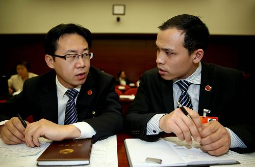 3月9日,董林(右)在山西代表团全体会议上与全国人大代表石文斌交谈。新华社记者 陈建力 摄